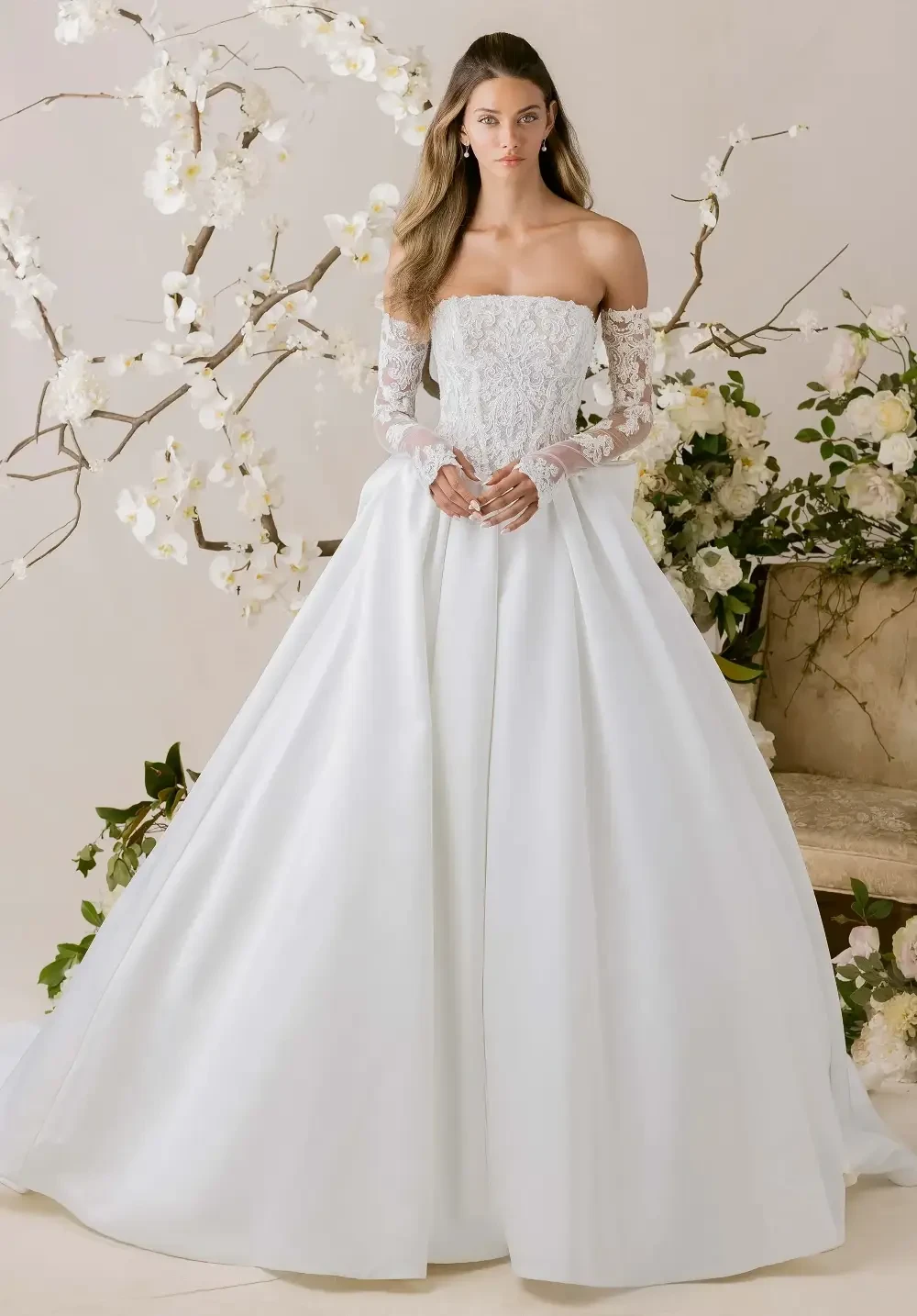 model is wearing an off the shoulder lace bridal gown